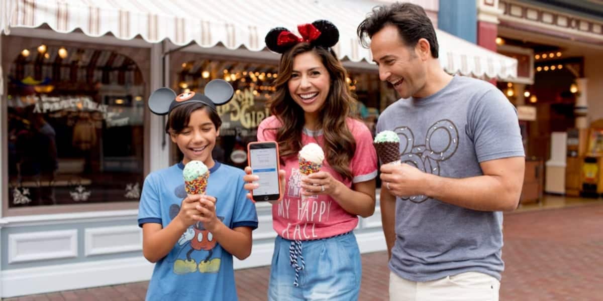 Disney World guests eating ice cream and looking at cell phone