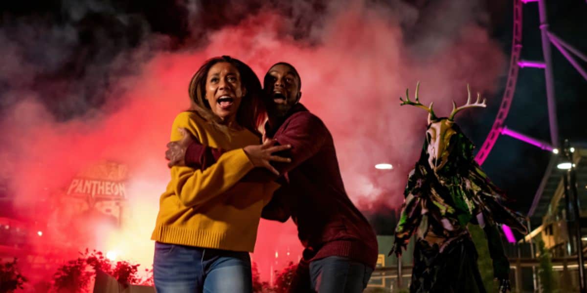 A woman and a man, both with surprised expressions, look scared at Busch Gardens Williamsburg's Howl-O-Scream.