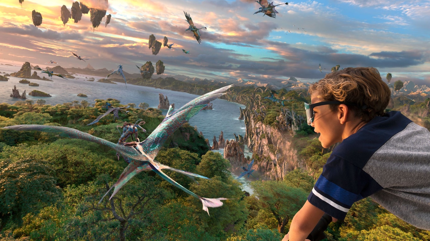 An illustration of the Avatar Flight of Passage attraction and a boy flying with banshee over water