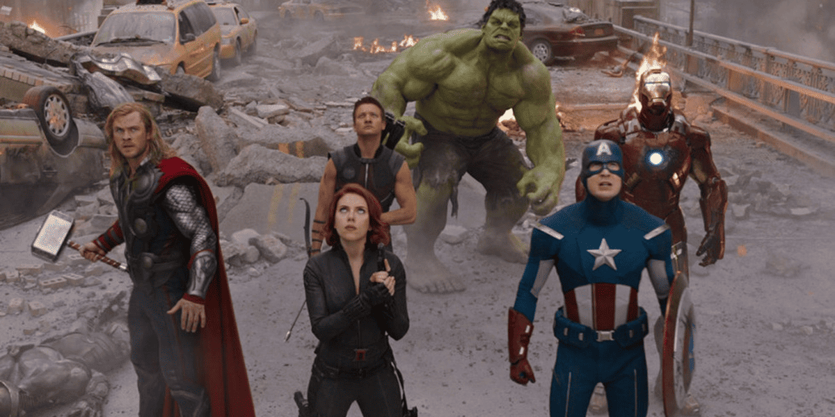 Marvel's Avengers including Thor, Black Widow, Captain Avenger, Hawkeye, Iron Man, and the Hulk, look up at the destruction of the city.