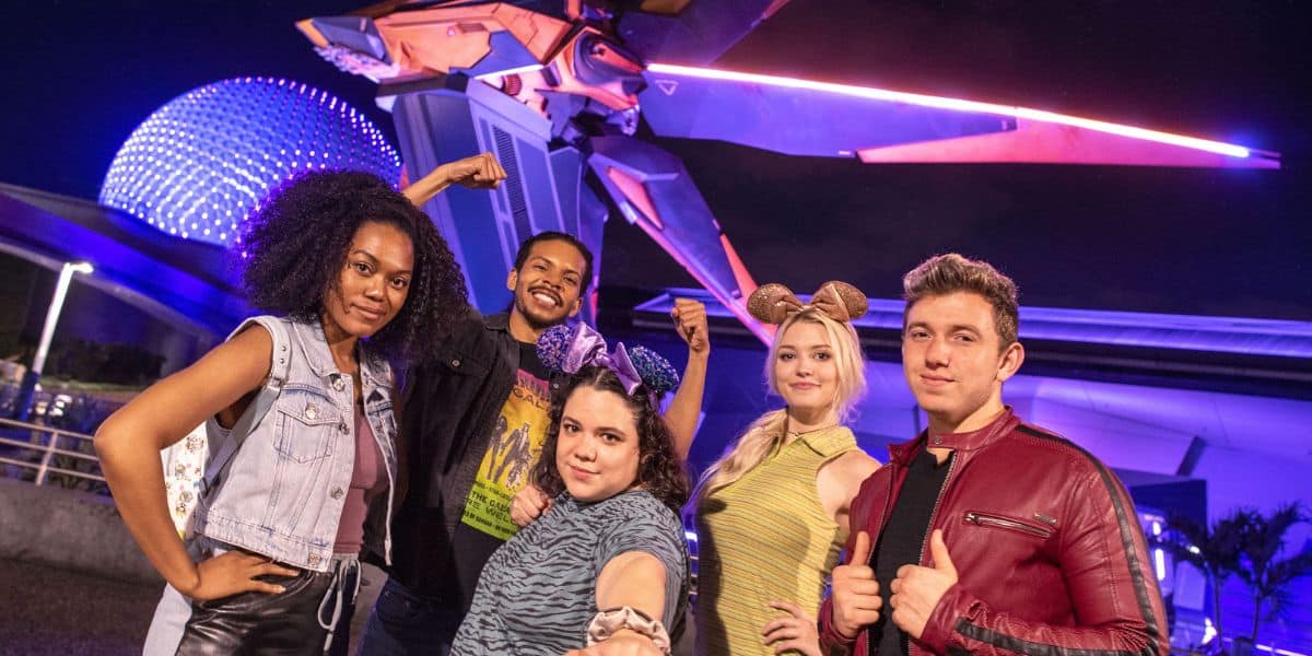 A group of young adults pose in front of the entrance to Guardians of the Galaxy: Cosmic Rewind at EPCOT during an After Hours event