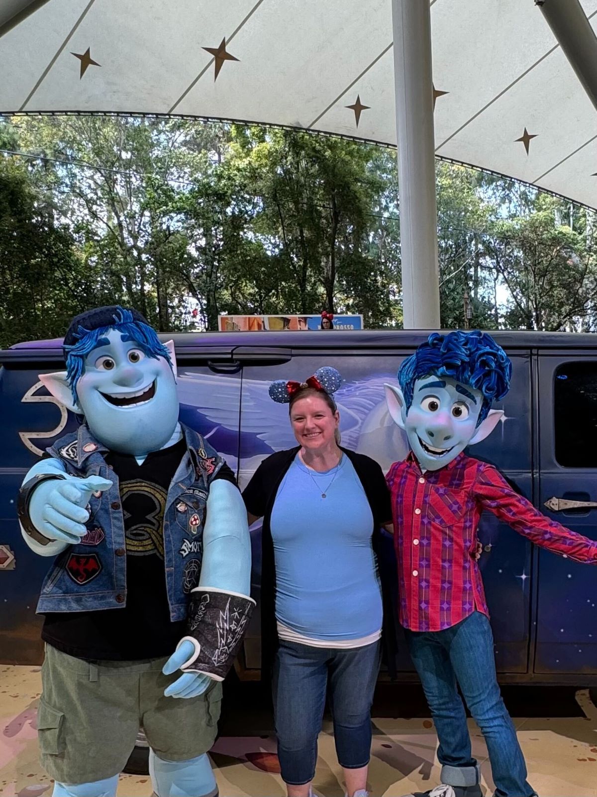 A guest posing with Ian Lightfoot and Barley Lightfoot in front of Guinevere from the Pixar movie 'Onward' (2020)