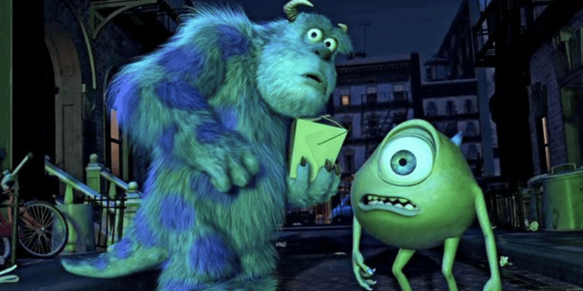 Two animated characters from Monsters Inc, a large furry blue monster and a small green one-eyed monster, standing on a city street at night, holding an envelope.