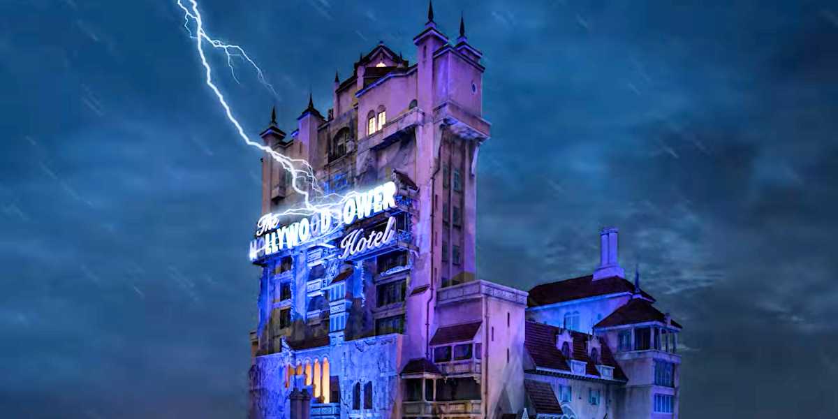 An image of the Tower of Terror, a gloomy, haunted-looking building, illuminated by a neon sign under a stormy sky with a lightning bolt striking.