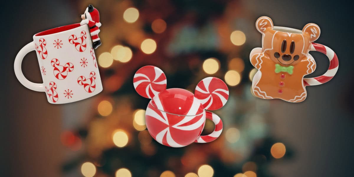 Three festive Mickey mugs with peppermint and gingerbread designs are displayed against a blurred Christmas tree background. One mug features a Santa figure, another has a peppermint swirl, and the third is shaped like a gingerbread character, perfect for the enchanting Disney holiday season.