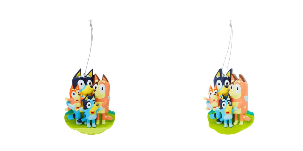 Two identical ornaments featuring a family of cartoon dogs, reminiscent of Bluey, stand together on a green base, each with a string for hanging. The festive canine family consists of four dogs, each with distinct colors and expressions.