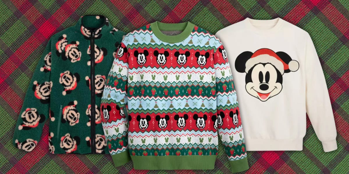 Three stylish Christmas-themed sweaters from Santa Mickey’s Holiday Collection are displayed side by side on a green and red plaid background. These cozy sweaters feature festive patterns and charming Mickey Mouse motifs, perfect for the holiday season.