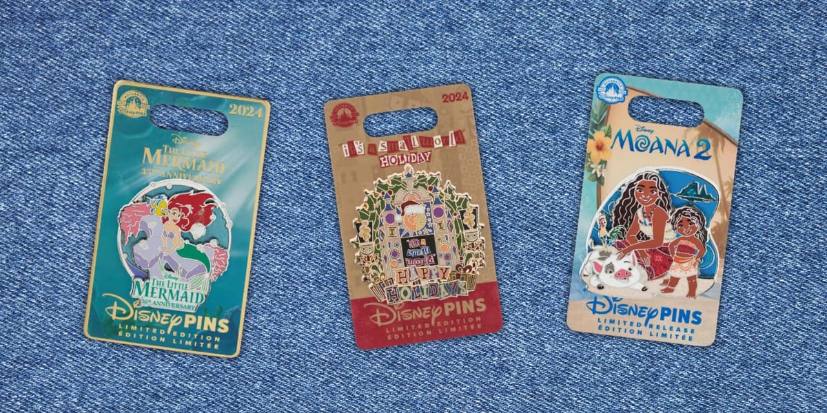 Three Limited Release Disney pin packs on a denim background. From left to right: "The Little Mermaid" 2024, "Resilient Holiday" 2024 with festive design, and "Moana 2" featuring two characters and colorful patterns—perfect finds for avid collectors.