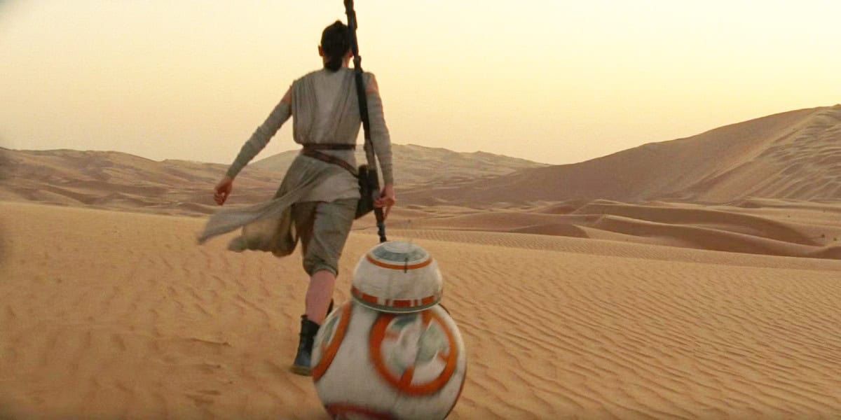 Rey (Daisy Ridley) and BB-8 walking along a desert in the 'Star Wars' sequel trilogy