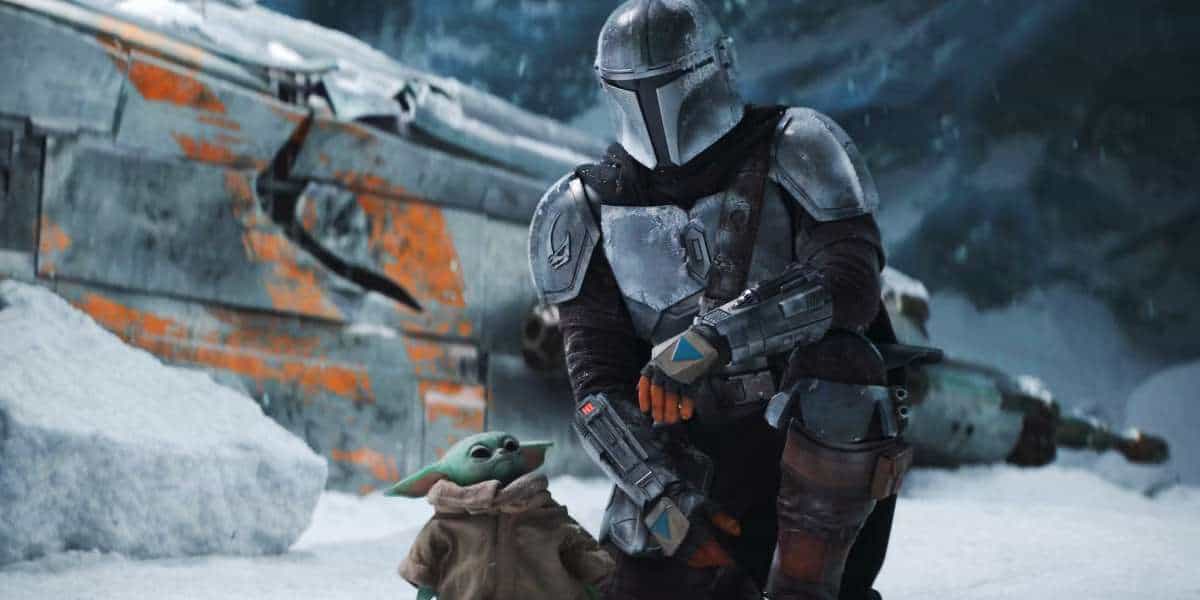 Din Djarin (Pedro Pascal) and Grogu kneel by a ship in Season 1 of 'The Mandalorian'