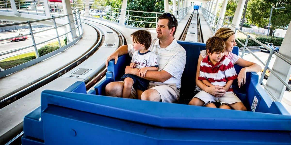 Two sons sit on their parents' laps as they ride the Peoplemover amidst talks of Disney parents "bullying" kids