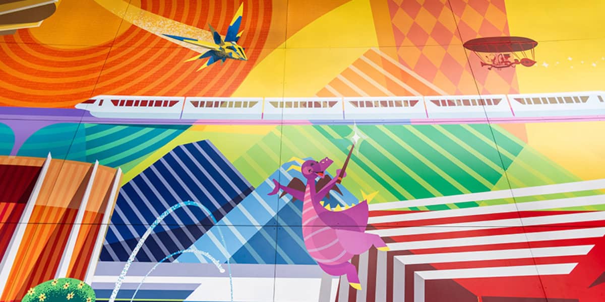 A vibrant mural features a futuristic scene with a monorail gliding through colorful abstract patterns. A purple dragon holding a wand flies above, while a vintage airship soars in the sky. Geometric shapes and lines add depth and dynamism to the artwork.