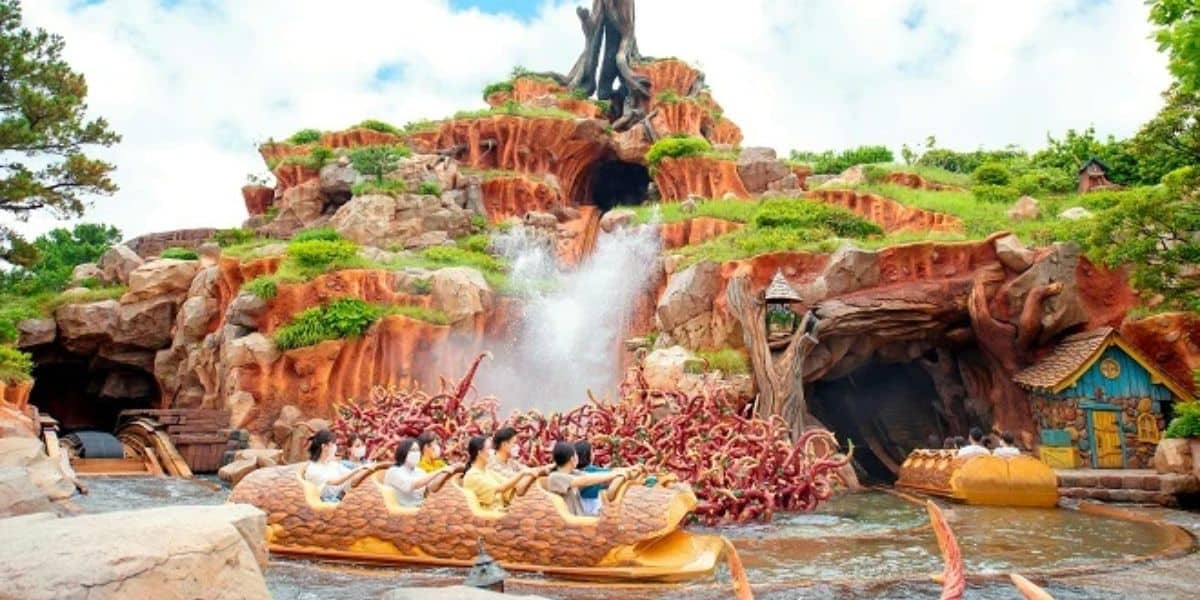 Guests ride on logs through water on Splash Mountain