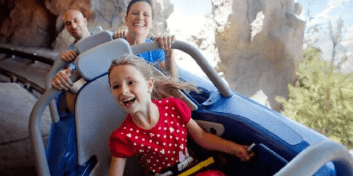 A little girl in a red dress grins on the Matterhorn.