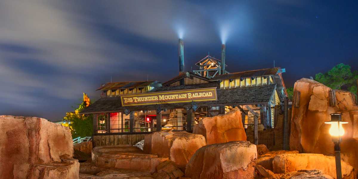 A nighttime image of the Big Thunder Mountain Railroad entrance at Magic Kingdom.