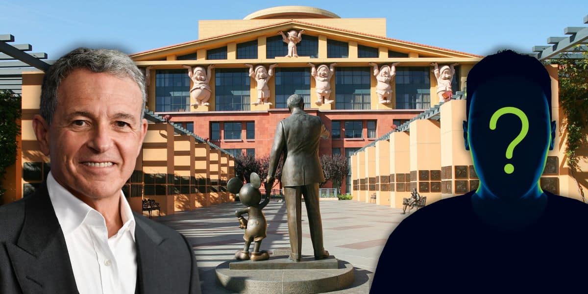 A man in a suit and another figure, possibly a new candidate, with a question mark for a face stand before Disney's iconic building adorned with large sculptures. In the foreground, the statue of Walt Disney holds Mickey Mouse's hand as if contemplating his legacy.