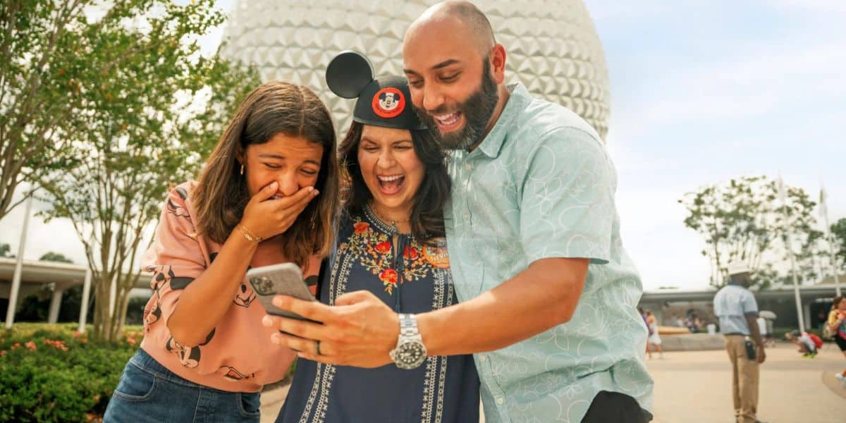 A family on vacation in EPCOT at Walt Disney World Resort, excited about the new Disney World summer discounts coming soon for this other event called V.I.Passholder Days this summer.
