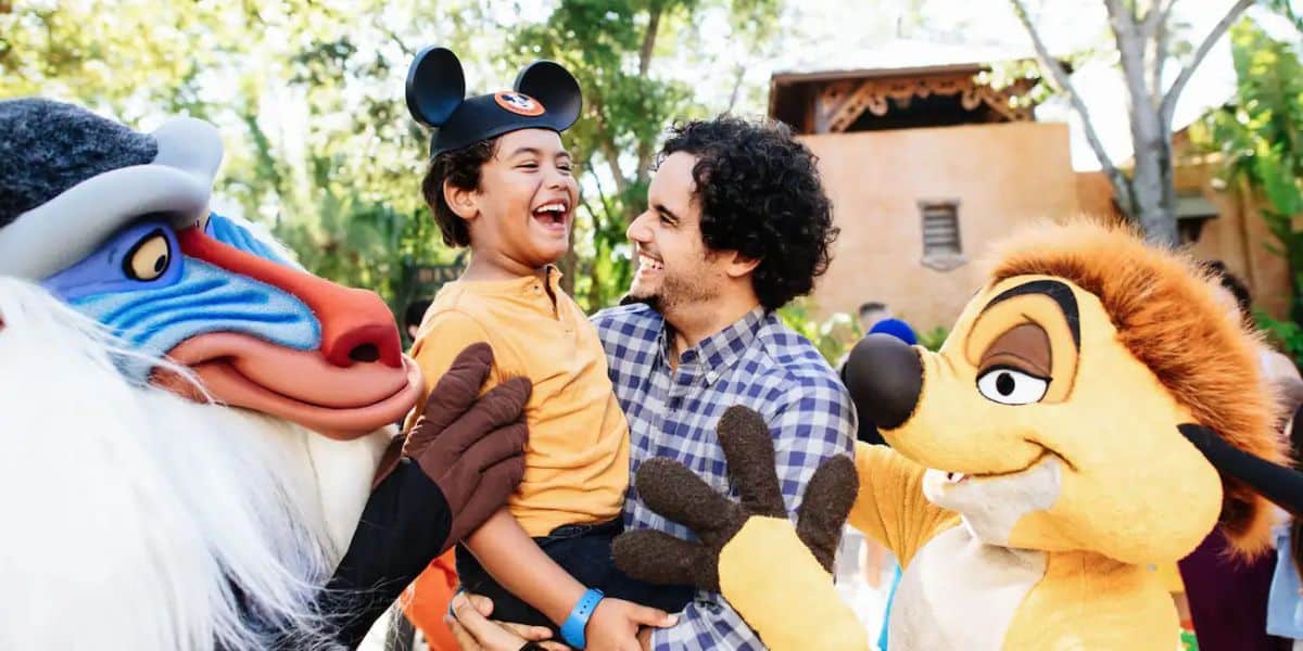 A man and his son with Rafiki and Timon at Disney's Animal Kingdom.