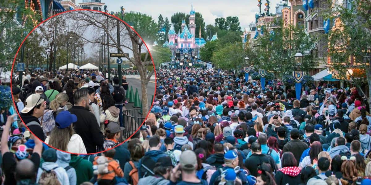 A large crowd fills an outdoor theme park, with many people wearing colorful hats and jackets. In the background, a fairytale-style castle is visible. A circular inset highlights a section of the dense crowd near a fenced area with trees as Disneyland Spring Break crowds descend on California at Disneyland Resort.