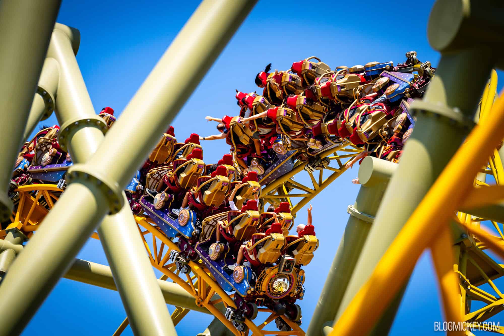 People riding a dueling roller coaster as one coaster spins over the other