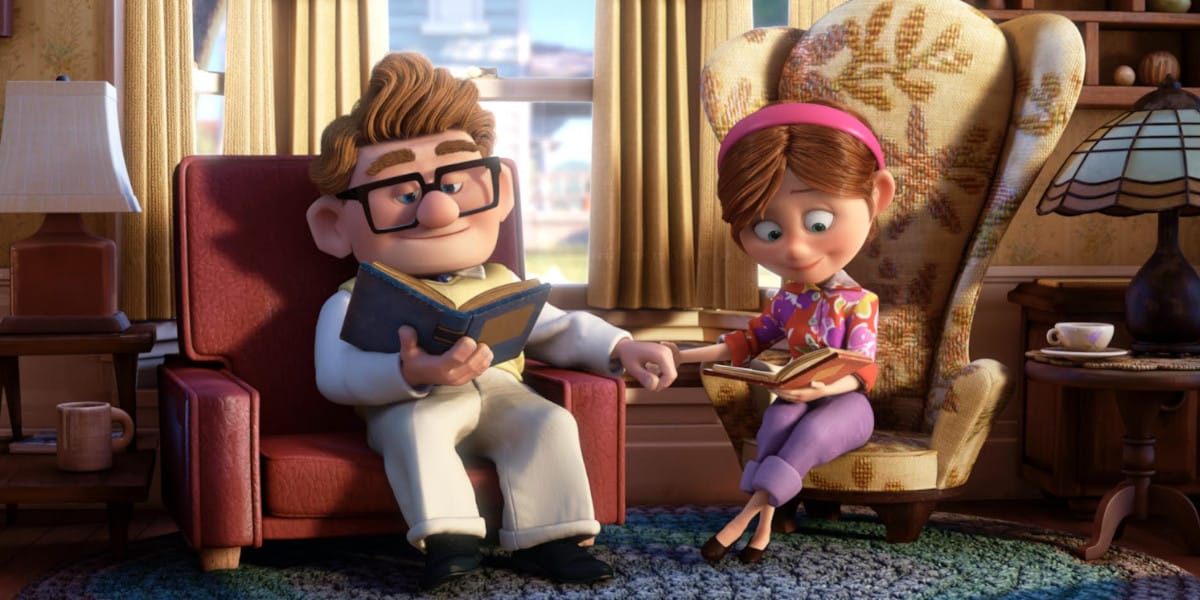 In a scene reminiscent of a Pixar classic, an elderly animated couple sits in their cozy living room. The man, bespectacled, reads peacefully in an armchair, while the woman in a headband enjoys her book on a patterned seat. As they hold hands, nostalgia and warmth fill the room.