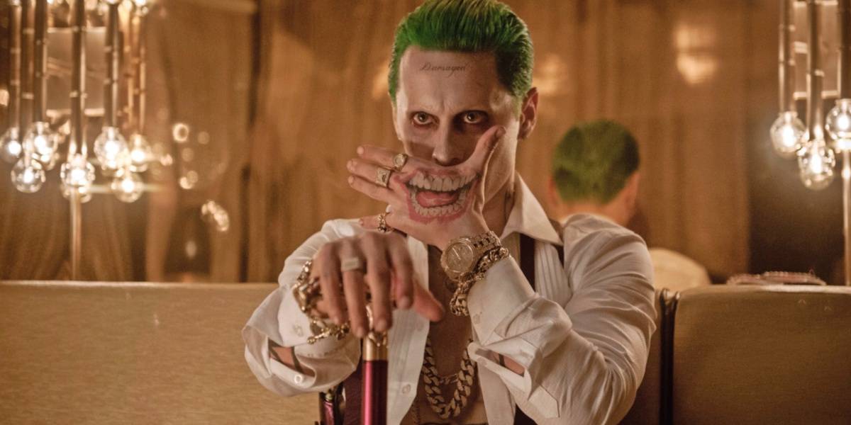 Jared Leto as Joker in 'Suicide Squad' covering his mouth with his hand that has a mouth tattoo