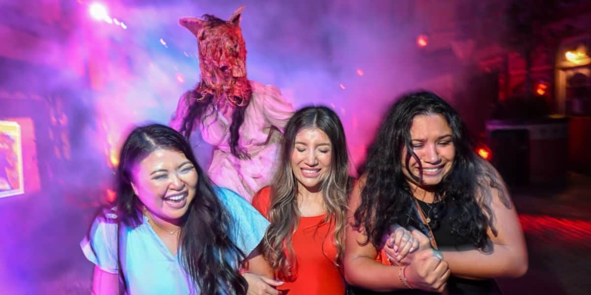 Guests run away from a monster at Halloween Horror Nights