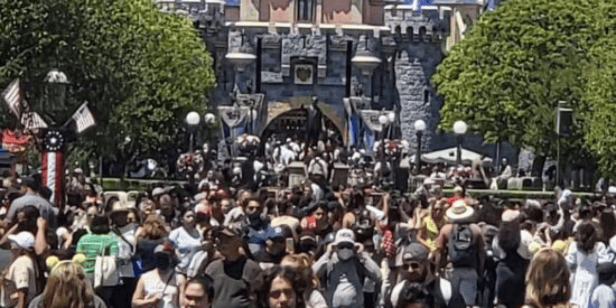 Crowds packed in front of Sleeping Beauty Castle at Disneyland Park.