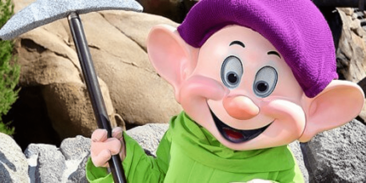 Dopey holding a a shiny silver pickaxe.