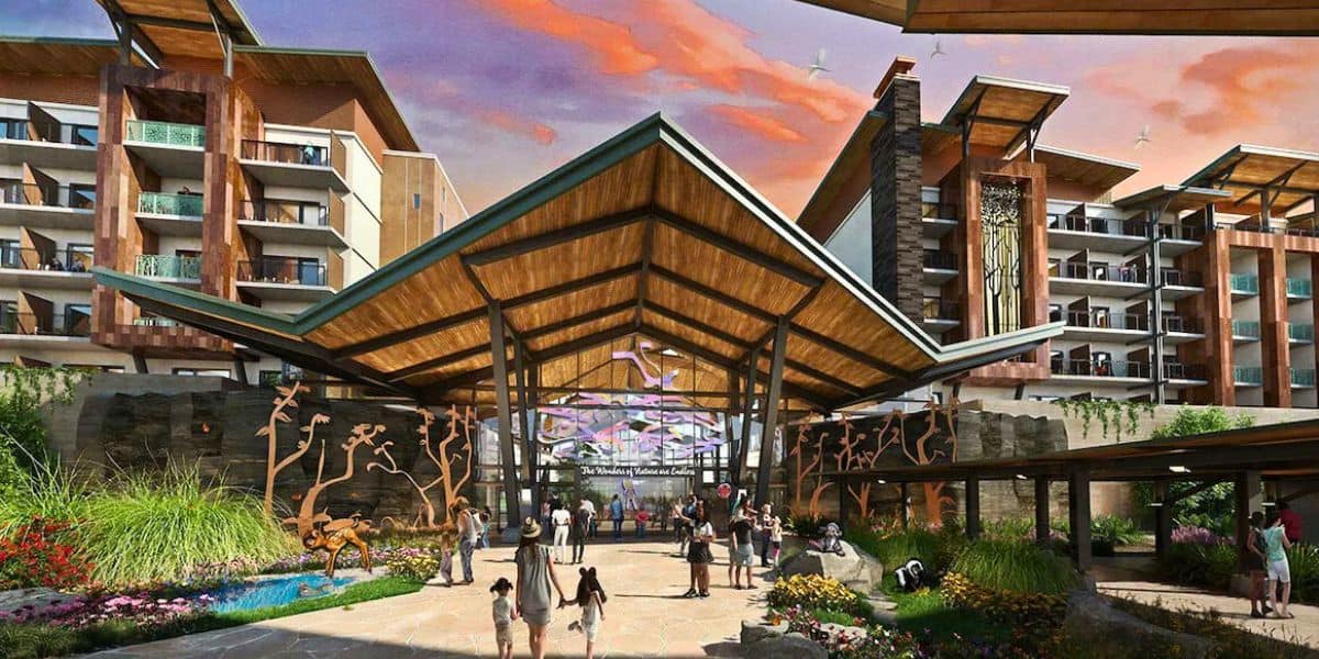 The vibrant entrance to this new resort showcases modern architecture with a high wooden canopy and decorative metal tree sculptures. People gather around the walkway, as the sky tinged with orange and purple hues suggests a magical sunset, reminiscent of Disney World charm.