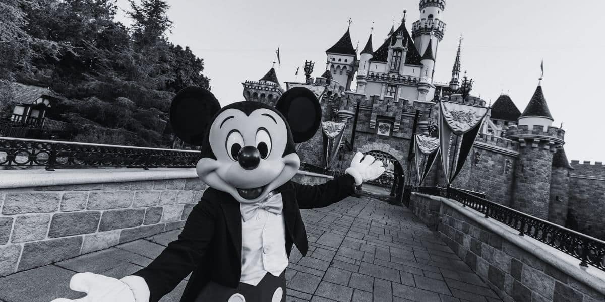 Mickey Mouse in front of the Disneyland Resort castle in California in black and white