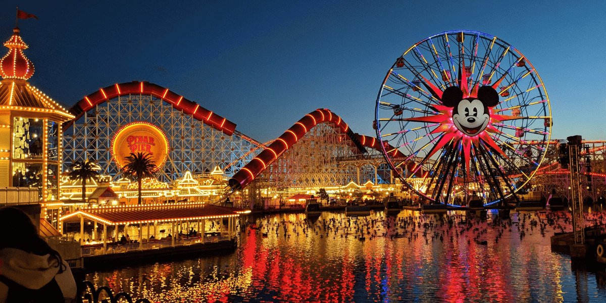 A view of Pixar Pier at night, overlooking the lake. You can see Pixar Pal-A-Round and Incredicoaster.