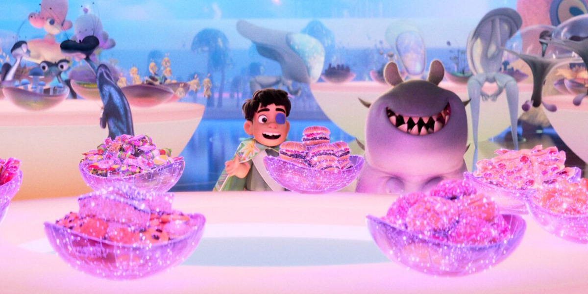 A boy and a smiling creature sit behind glowing bowls of colorful, sparkly treats in a whimsical, brightly lit setting reminiscent of Disney Parks, with fantasy characters and floating objects in the background.