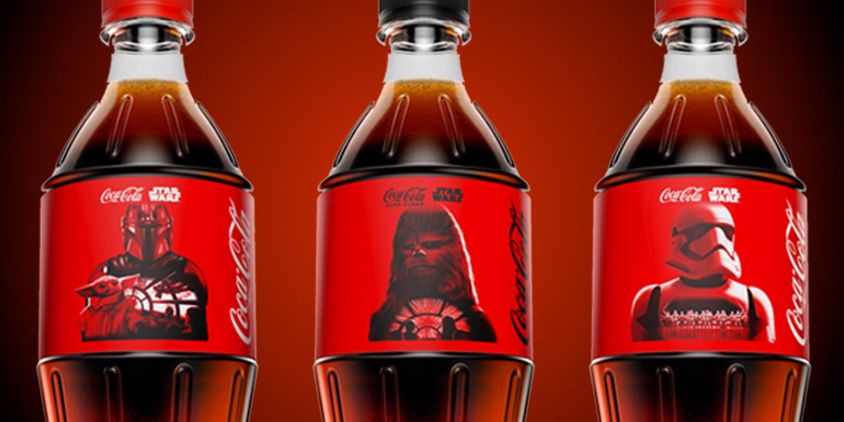 Three Coca-Cola bottles with red labels featuring Star Wars characters: The Mandalorian, Chewbacca, and a Stormtrooper, against a red gradient background.