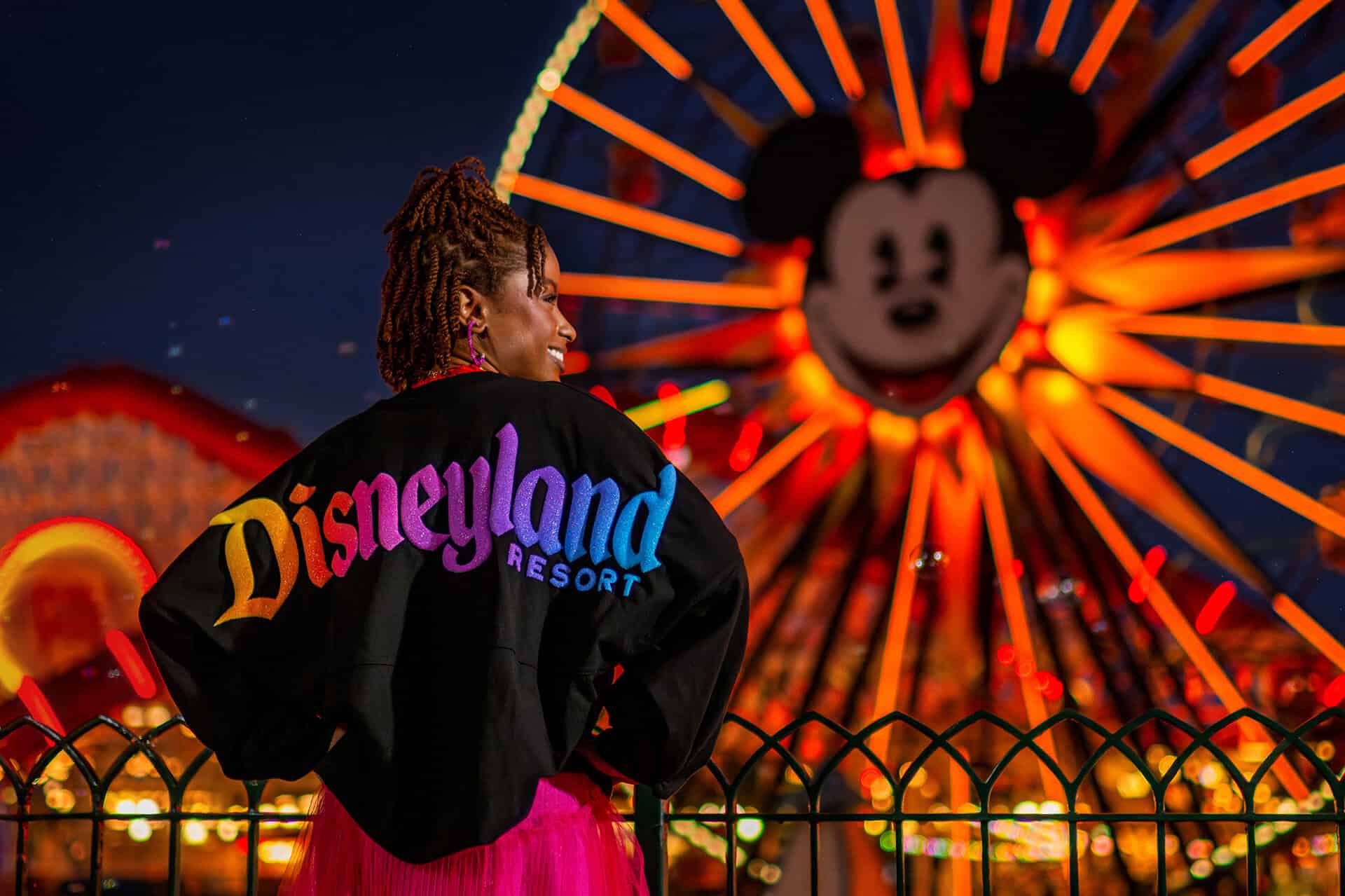 A woman wears a Disneyland spirit jersey in front of California Adventure ferris wheel