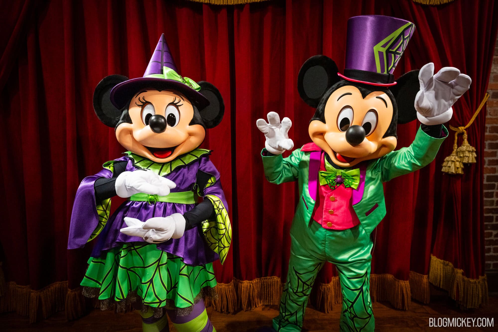 Colorful Disney characters Mickey and Minnie Mouse in Halloween costumes at Town Square Theater.