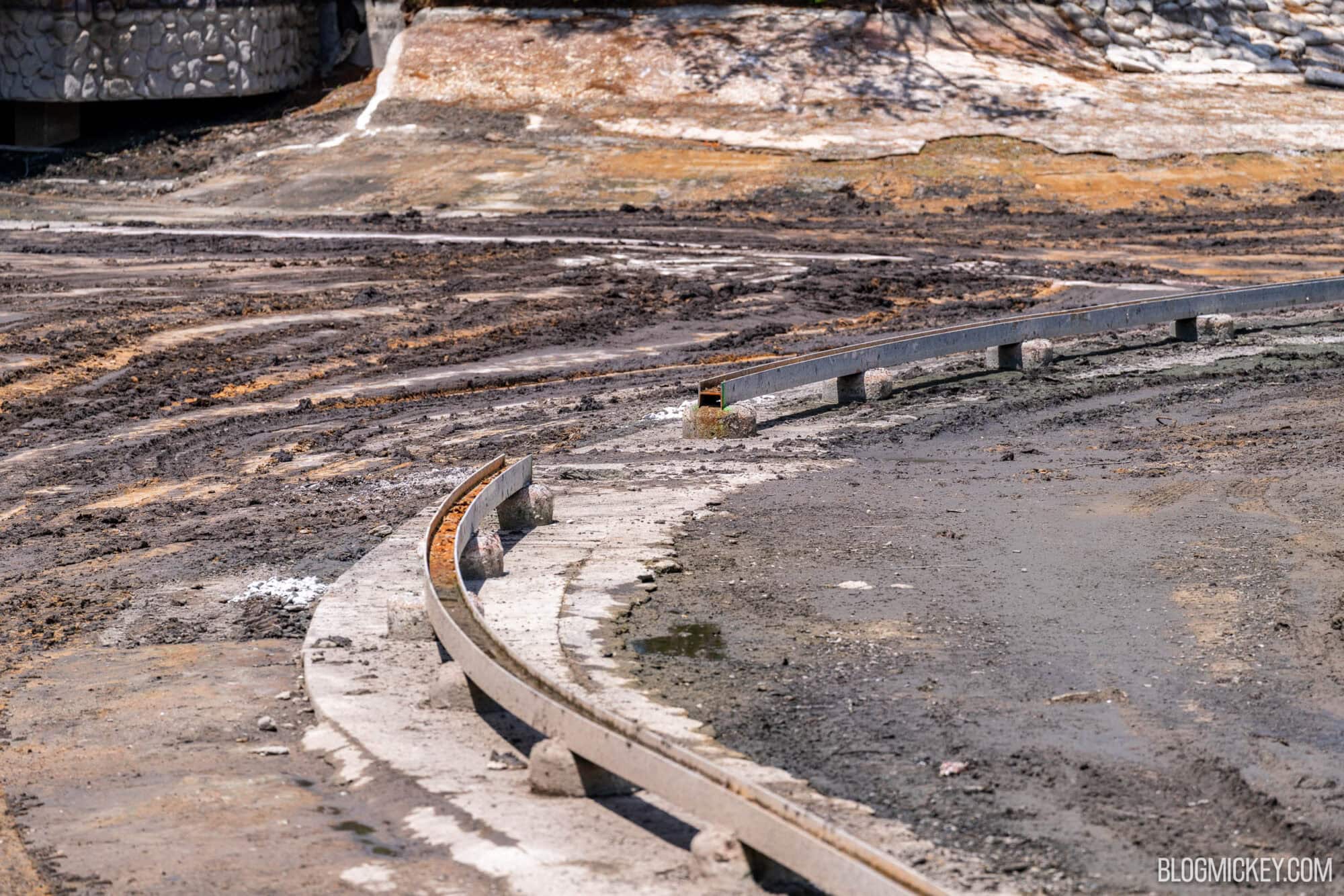 Dried riverbed with a curved metal track with a peice cut out