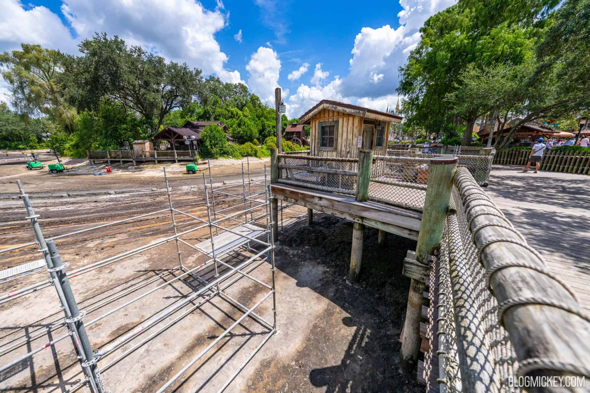 Drained Rivers of America riverbed with ongoing scaffolding constrcution near a wooden boardwalk