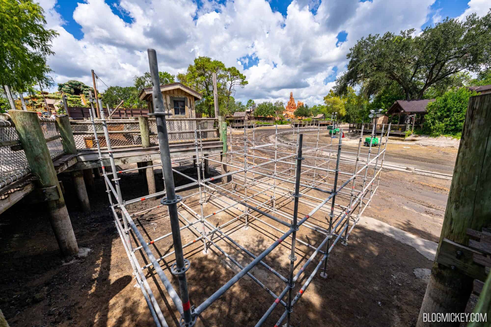 Drained Rivers of America riverbed with ongoing scaffolding constrcution near a wooden boardwalk