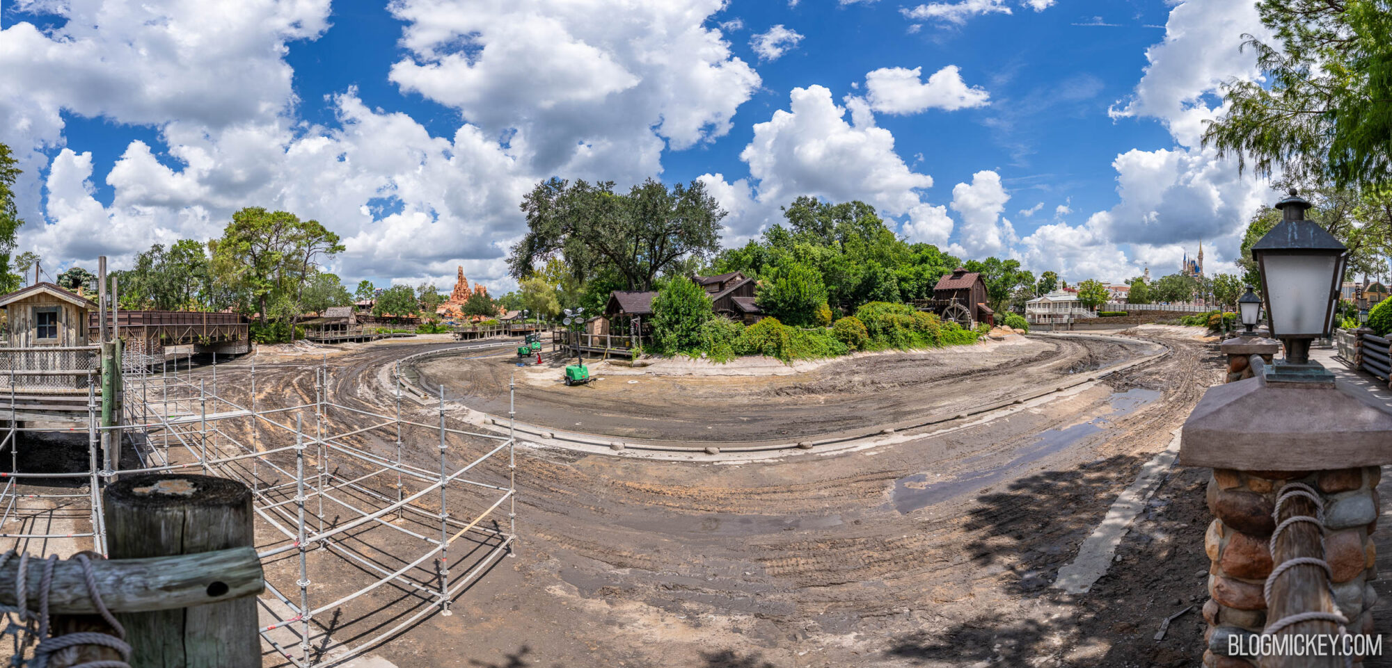 Drained Rivers of America with scaffolding, trees, and partly cloudy sky, indicating ongoing park expansion