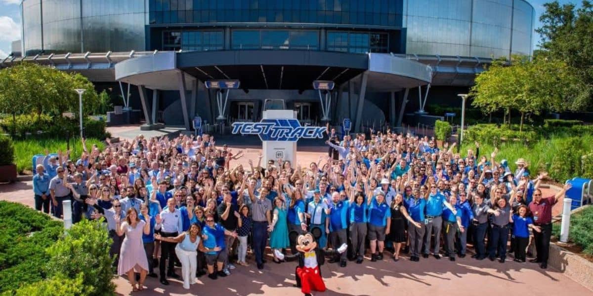 Large group of cast members and Mickey Mouse in front of the new Test Track attraction at EPCOT
