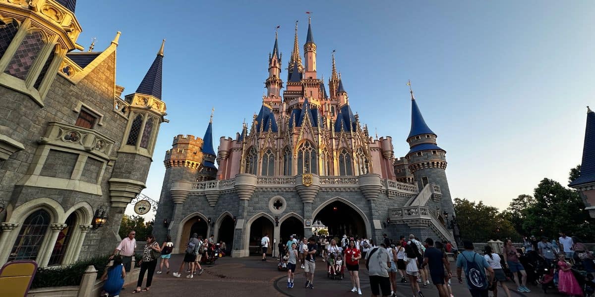 Guests walking in Fantasyland at Magic Kingdom behind Cinderella Castle