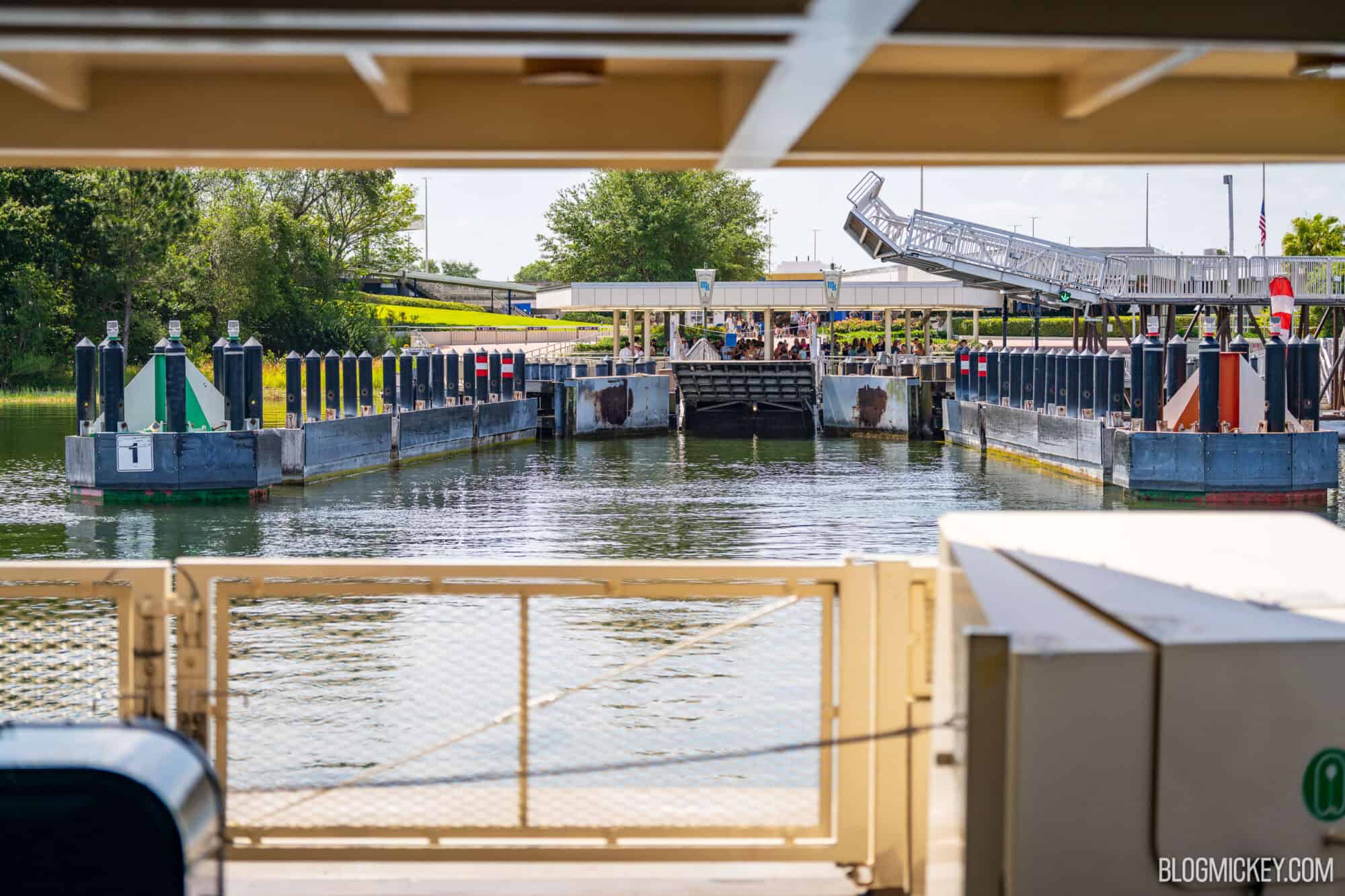U-shaped ferryboat dock at Disney World with park guests waiting to board in the background