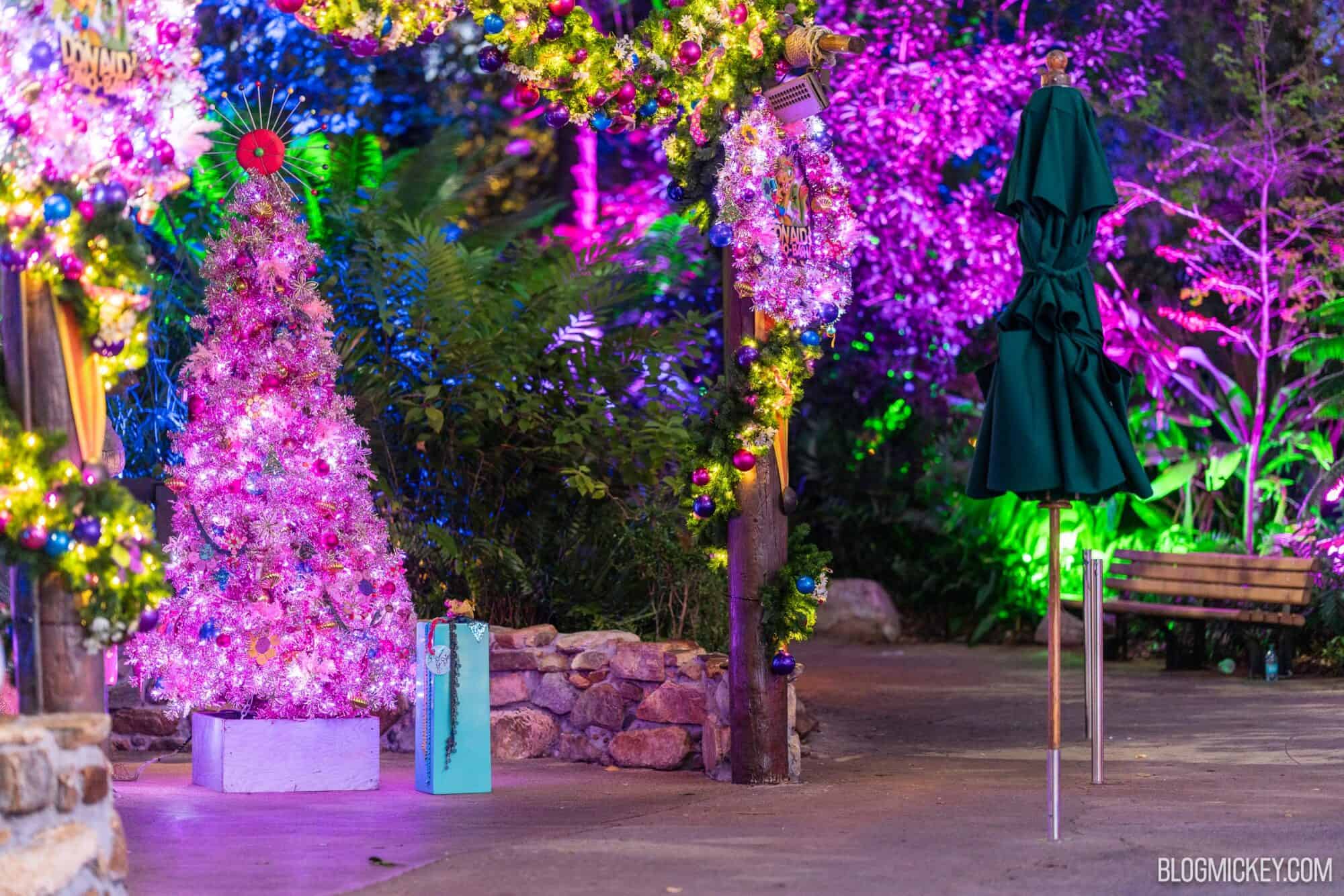 Colorful decorated Christmas trees with vibrant lights and ornaments at night.