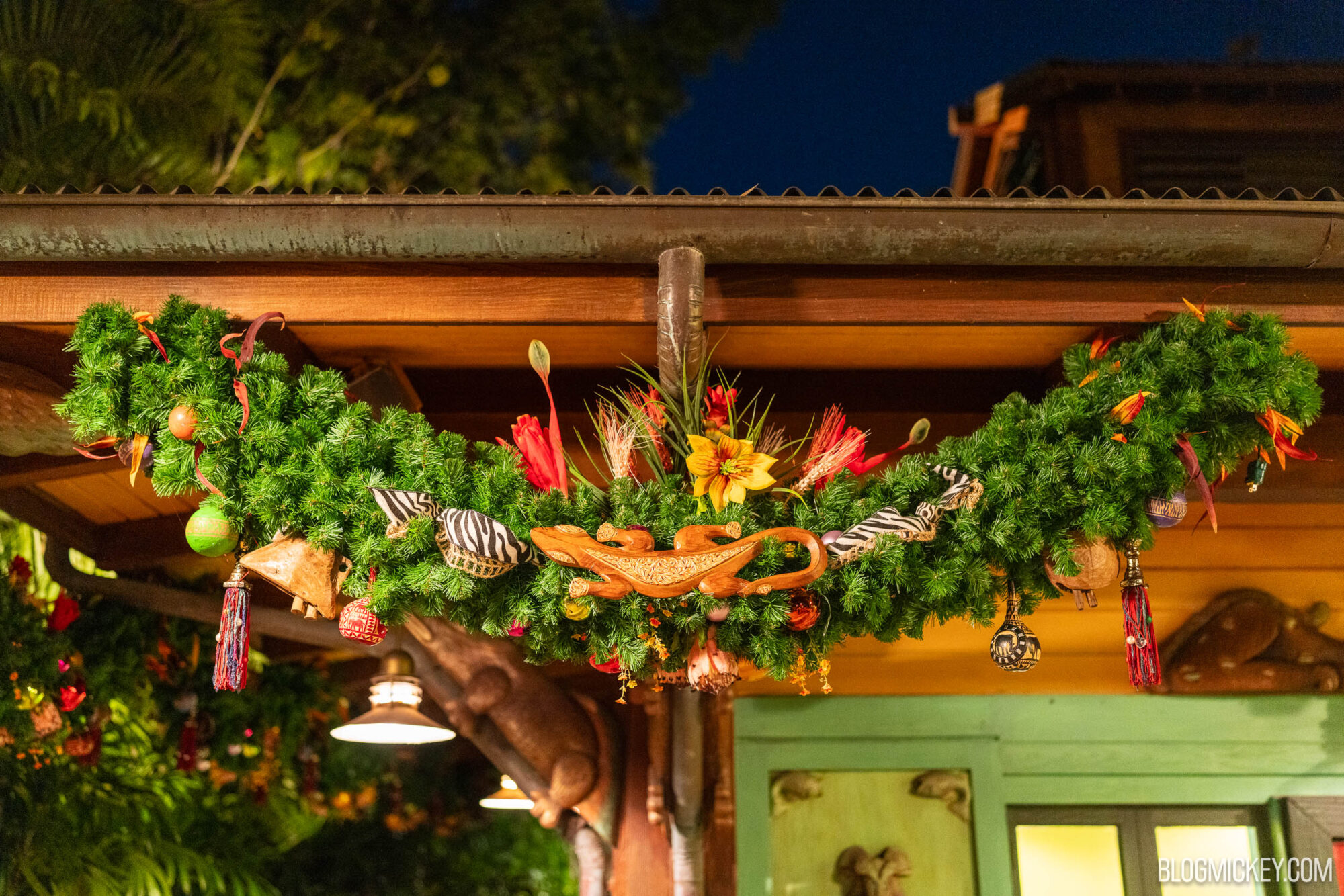 Colorful tropical-themed Christmas garland with ornaments and wooden animal figurine.