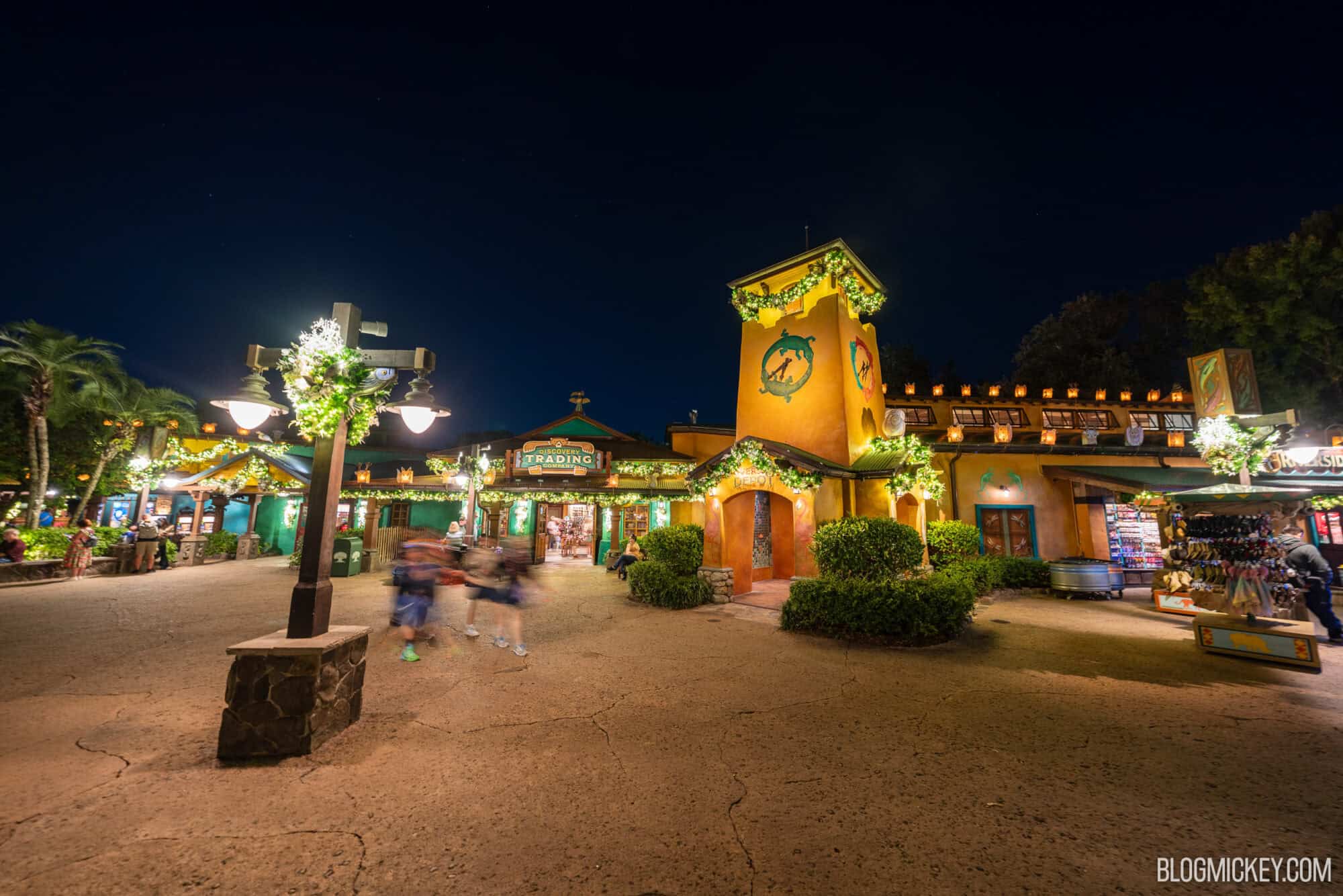 Colorful nighttime scene at Disney World's themed shopping and dining area.