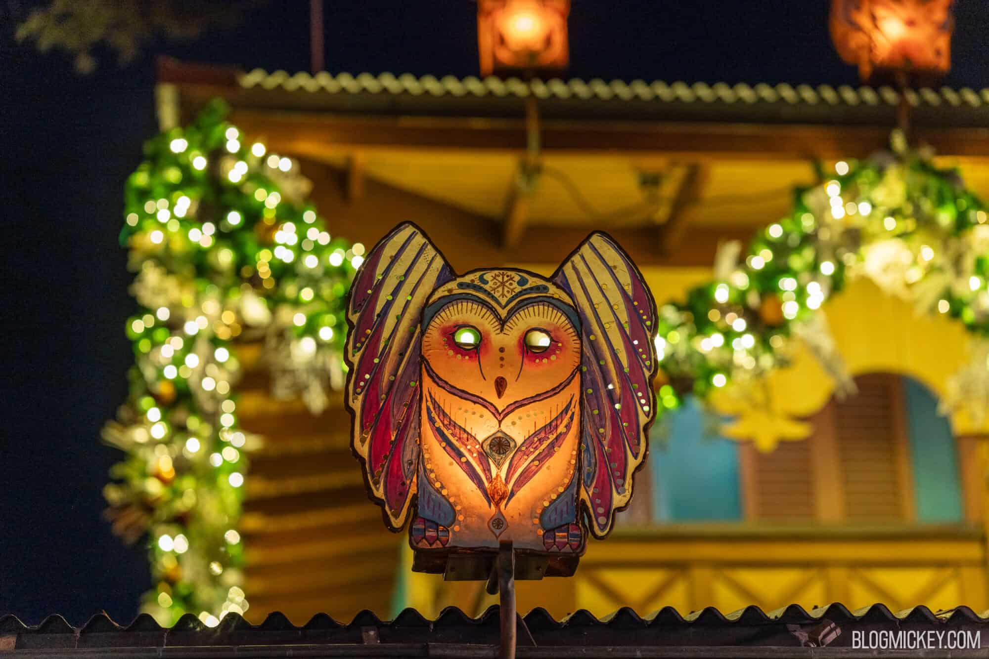Colorful owl lantern illuminated at night during Christmas festival at Disney World.