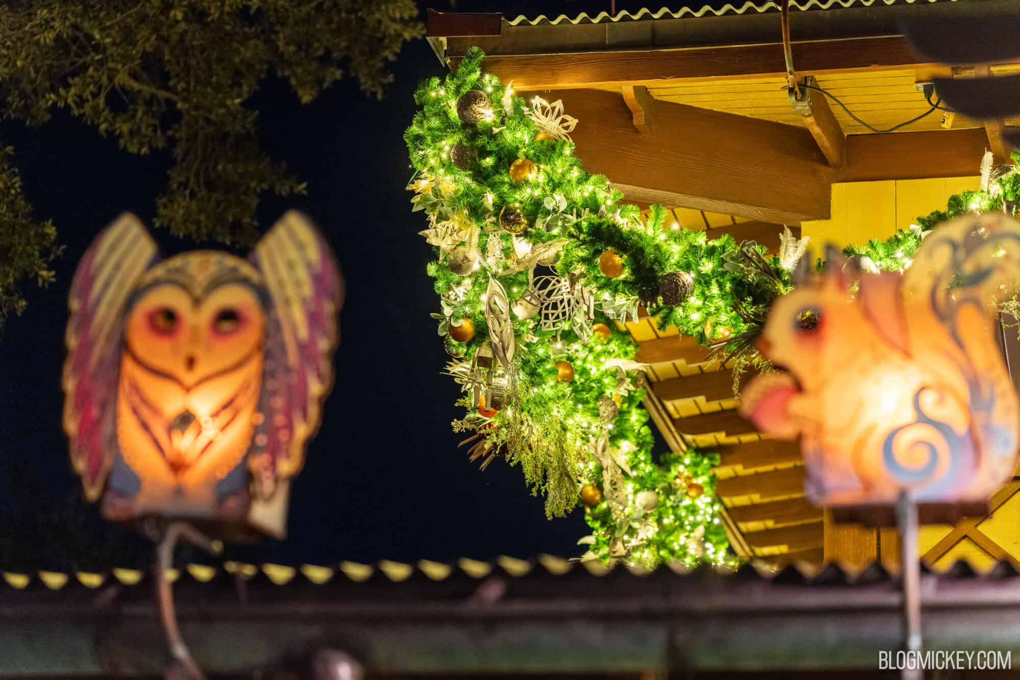 Decorated Christmas garland with ornaments at night at Disney theme park.