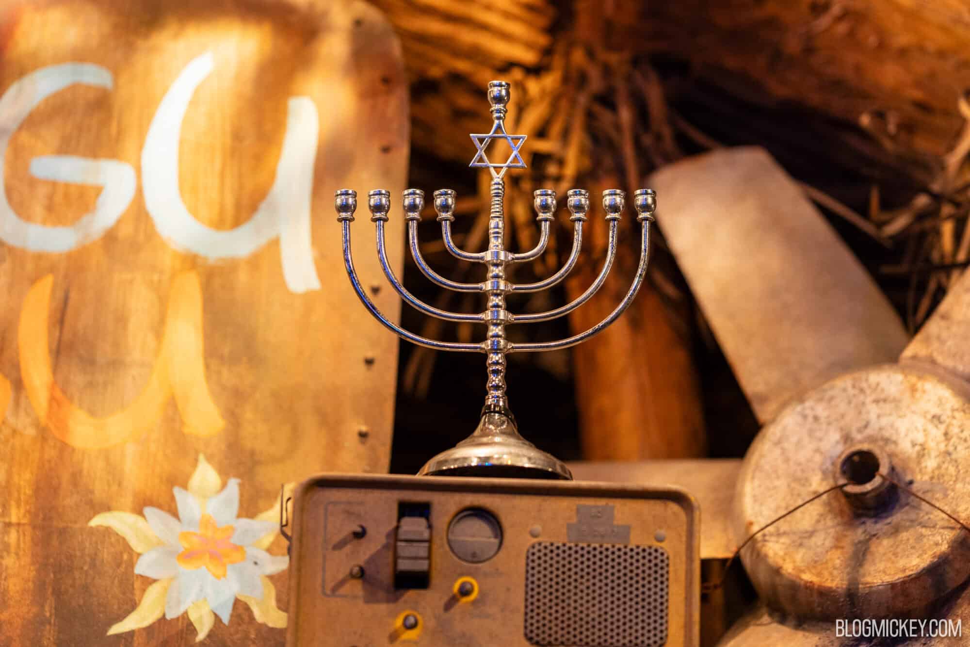Shalom menorah with a Star of David on top, placed on a vintage radio set with wooden and metal objects in the background.